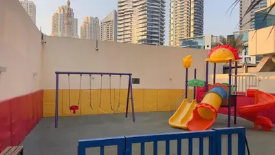 a playground with a slide and a swing set at Spacious and Cozy 1BR Opal Tower Stunning Marina View in Dubai