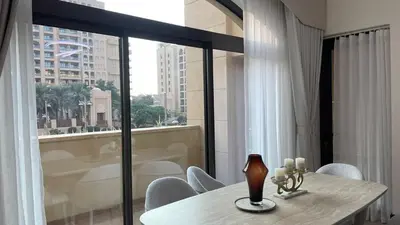 a table and chairs in a room with a large window at Luxury 1-Bedroom, Golden Mile Palm Jumeirah in Dubai