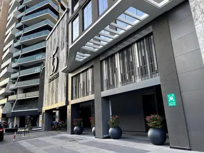 a large building with large windows and pots of flowers at Luxury 2BR Apt | Infinity Pool with Burj View in Dubai