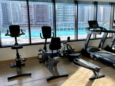 a gym with cardio equipment in front of a large window at Luxury 2BR Apt | Infinity Pool with Burj View in Dubai