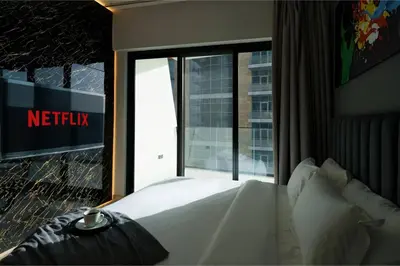 a hotel room with a bed and a window with a netflix sign at Luxury 2BR Apt | Infinity Pool with Burj View in Dubai