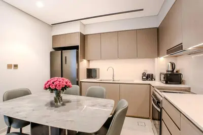 a kitchen with a table with a vase of flowers on it at Ultra-luxury apartment |Stunning Burj Khalifa view in Dubai