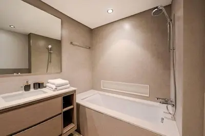 a bathroom with a tub and a sink and a mirror at Ultra-luxury apartment |Stunning Burj Khalifa view in Dubai