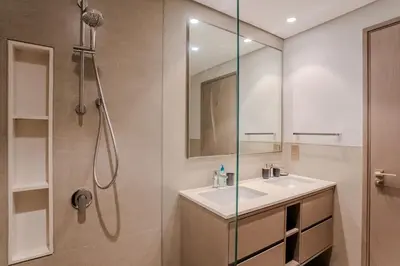 a bathroom with a sink and a shower with a mirror at Ultra-luxury apartment |Stunning Burj Khalifa view in Dubai
