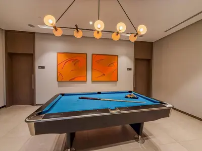 a pool table in a room with two paintings at Ultra-luxury apartment |Stunning Burj Khalifa view in Dubai