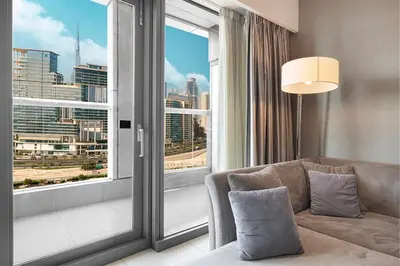 a living room with a couch and a large window at 2 bedroom in heart of Business Bay - Dubai in Dubai