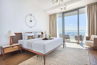 a white bedroom with a large bed and a couch at Frank Porter - Stella Maris in Dubai
