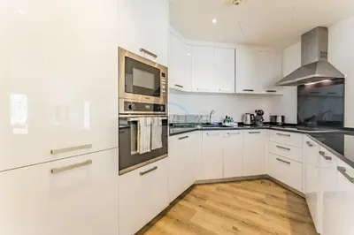 a kitchen with white cabinets and a microwave at Exclusive Waterfront Residence with Private Beach Access, Near Palm Jumeirah Mall and Restaurants - Jash Hamad Shoreline B18, Palm Jumeirah by Deluxe Holiday Homes in Dubai