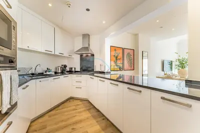 a kitchen with white cabinets and black counter tops at Exclusive Waterfront Residence with Private Beach Access, Near Palm Jumeirah Mall and Restaurants - Jash Hamad Shoreline B18, Palm Jumeirah by Deluxe Holiday Homes in Dubai