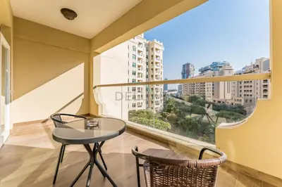 a balcony with a table and chairs and a large window at Exclusive Waterfront Residence with Private Beach Access, Near Palm Jumeirah Mall and Restaurants - Jash Hamad Shoreline B18, Palm Jumeirah by Deluxe Holiday Homes in Dubai