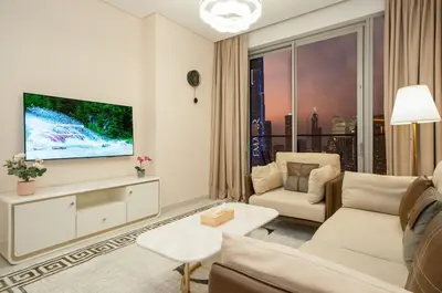 a living room with a couch and a tv at 2BR Vida Dubai Mall Burj Khalifa & Fountain View in Dubai
