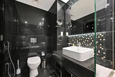 a black bathroom with a toilet and a sink at Bloomfields Luxury 1BR, Damac Voleo, Business Bay in Dubai