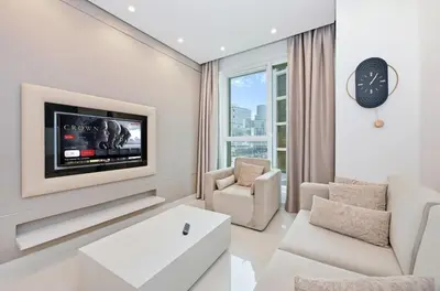 a living room with a tv on a wall at Bloomfields Luxury 1BR, Damac Voleo, Business Bay in Dubai