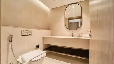 a bathroom with a toilet and a sink and a mirror at Contemporary 2BR in Central Park Viridian in Dubai
