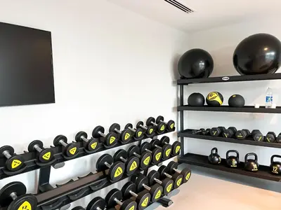a gym with a wall of dumbbells and a tv at Burj Crown 3BR Skyline Retreat with Balcony in Dubai