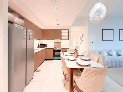 a kitchen and living room with a table and chairs at Burj Crown 3BR Skyline Retreat with Balcony in Dubai