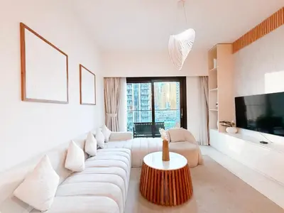 a white living room with a couch and a tv at Burj Crown 3BR Skyline Retreat with Balcony in Dubai