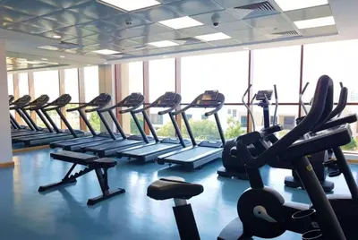 a gym with rows of tread machines in a row at Silk Valley - Luxury Studio with Pool View - Walk to Park in Dubai