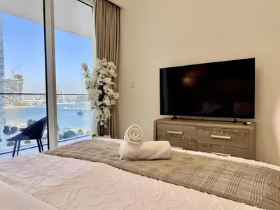 a bedroom with a flat screen tv and a bed at BRAND NEW 2 BDR apartment with beach access in Dubai