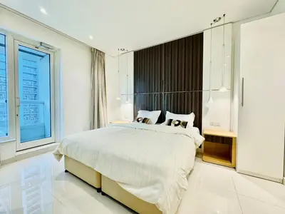 a white bedroom with a large bed and a window at Homes2Retreat - Stylish 1BR with Balcony in Business Bay in Dubai