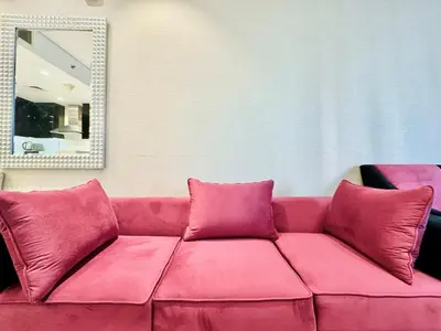 a pink couch in a room with a mirror at Homes2Retreat - Stylish 1BR with Balcony in Business Bay in Dubai