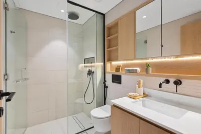 a bathroom with a toilet and a sink and a shower at Urban Chic 1 Bedroom with big Balcony Kitchen in JVC in Dubai
