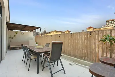 a patio with a table and chairs on a balcony at Urban Chic 1 Bedroom with big Balcony Kitchen in JVC in Dubai