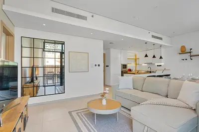 a living room with a couch and a table at Urban Chic 1 Bedroom with big Balcony Kitchen in JVC in Dubai