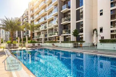 a swimming pool in front of a building at Modern 1BR Azizi Riviera with Pool & Gym in Dubai