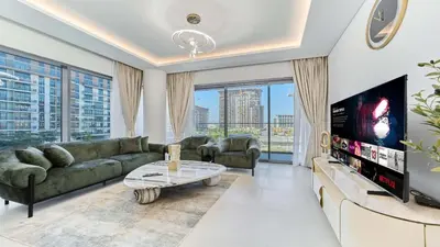 a living room with a couch and a tv at Modern 2BR in Viridian Central Park City Walk in Dubai