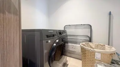 a washing machine in a laundry room with a basket at Modern 2BR in Viridian Central Park City Walk in Dubai