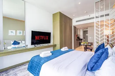 a bedroom with a large white bed with blue pillows at Modern Studio in Business Bay - Canal & City Views - Gym & Pool in Dubai