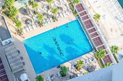 an overhead view of a large swimming pool with palm trees at Modern Studio in Business Bay - Canal & City Views - Gym & Pool in Dubai