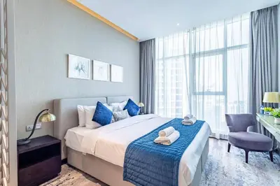 a bedroom with a bed and a desk and a chair at Modern Studio in Business Bay - Canal & City Views - Gym & Pool in Dubai