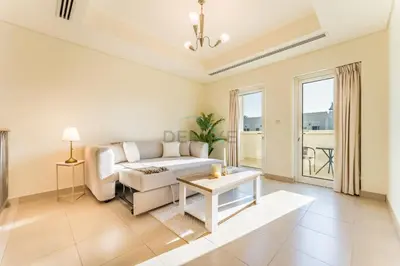 a living room with a couch and a table at Spacious 3BR and Assistant Room with Community View - Al Quortaj Villa, Al Furjan by Deluxe Holiday Homes in Dubai