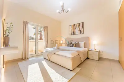 a white bedroom with a bed and a window at Spacious 3BR and Assistant Room with Community View - Al Quortaj Villa, Al Furjan by Deluxe Holiday Homes in Dubai