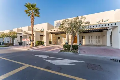 an empty street in front of a building with a stop sign at Spacious 3BR and Assistant Room with Community View - Al Quortaj Villa, Al Furjan by Deluxe Holiday Homes in Dubai
