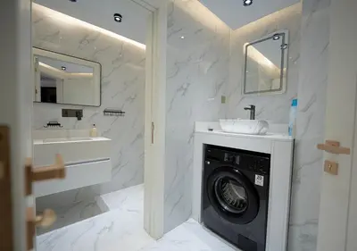 a bathroom with a washing machine and a sink at Luxury 3 Bed flat in Marina crown in Dubai