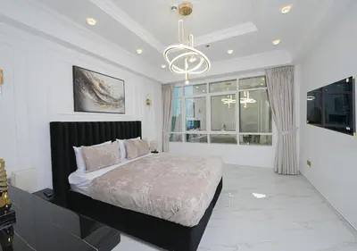 a bedroom with a large bed and a chandelier at Luxury 3 Bed flat in Marina crown in Dubai
