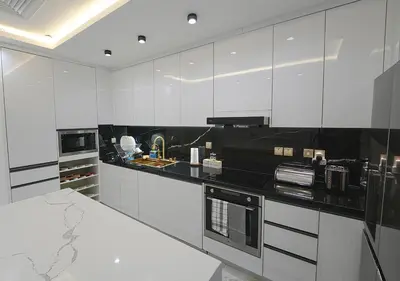 a kitchen with white cabinets and black counter tops at Luxury 3 Bed flat in Marina crown in Dubai