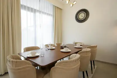 a dining room with a wooden table and chairs at Silk Valley - Luxury Villa | Steps to Park & Pool in Dubai
