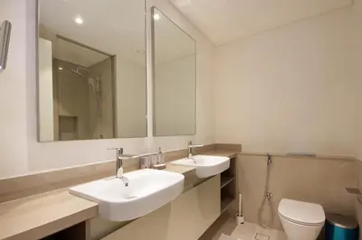 a bathroom with two sinks and a toilet and a mirror at Silk Valley - Luxury Villa | Steps to Park & Pool in Dubai