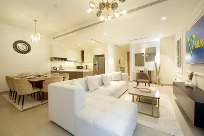 a living room with a white couch and a table at Silk Valley - Luxury Villa | Steps to Park & Pool in Dubai