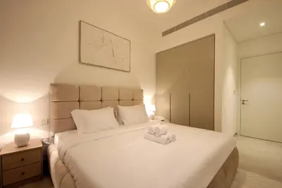 a bedroom with a large white bed with towels on it at Silk Valley - Luxury Villa | Steps to Park & Pool in Dubai