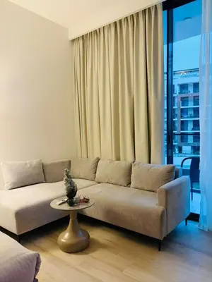 a living room with a couch and a table at Deluxe Studio for Rent in Oxford Gardens Dubai in Dubai