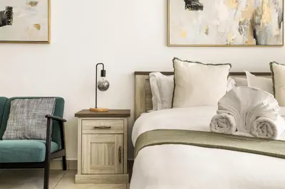 a bedroom with a bed and a chair at Relaxing Studio with Balcony & Pool at The Square Tower in Dubai