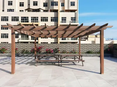 a wooden bench under a wooden canopy in front of a building at Relaxing Studio with Balcony & Pool at The Square Tower in Dubai