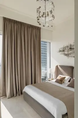 a bedroom with a large bed and a chandelier at Ultimate Beachfront family home with panoram views! in Dubai