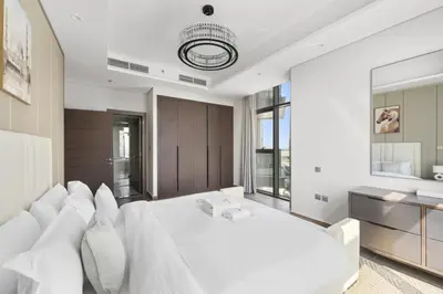 a white bedroom with a large white bed with white pillows at Modern 2BR at Nobles Tower Near Downtown in Dubai
