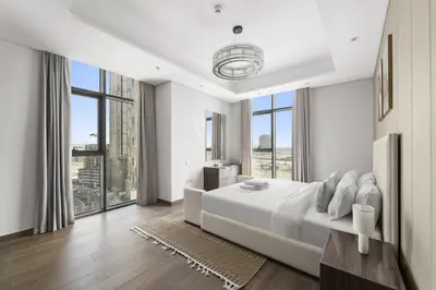 a white bedroom with a large bed and large windows at Modern 2BR at Nobles Tower Near Downtown in Dubai